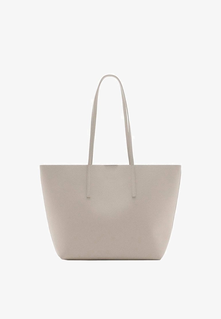 Sac fourre-tout en cuir beige avec de longues poignées et un design simple et sans ornement, présenté sur fond blanc.