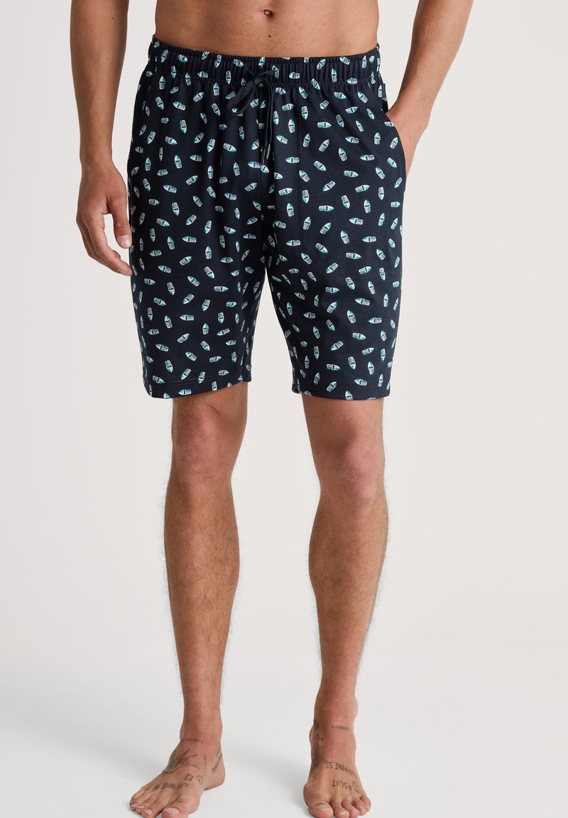 Marineblauwe zwemshorts met een herhaald patroon van lichtblauwe flessen, elastische tailleband met trekkoord, boven de knie lengte, gemaakt van lichtgewicht stof.