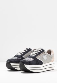 Platform sneakers with dark blue suede, gray fabric, and metallic accents. Features white stripes on the sole and a zip detail on the side.