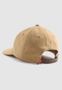 Khaki corduroy cap with a curved brim, adjustable back strap, and a red Levi's tag on the side. Textured fabric and stitched detailing.