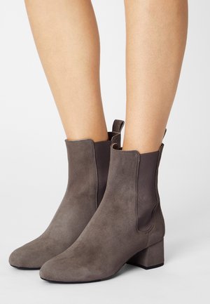 Bottines en suède grises avec un bout pointu, des panneaux latéraux élastiques et un petit talon carré. Texture lisse avec un design minimaliste.
