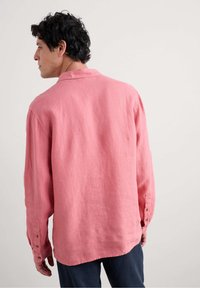 Rosa linne skjorta med en avslappnad passform, långa ärmar, knäppta manschetter och en klassisk krage. Texturerat tyg med en mjuk känsla.