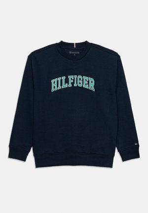 Μπλε ναυτικό φούτερ με στρογγυλή λαιμόκοψη, με ριμπ μανσέτες και τελείωμα, που φέρει το κείμενο "HILFIGER" με πράσινα και λευκά περιγράμματα στο στήθος.
