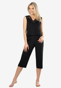 Czarny dwuczęściowy zestaw loungewear składający się z topu bez rękawów z koronkowym wykończeniem oraz spodni 7/8, wykonany z miękkiego, elastycznego materiału.