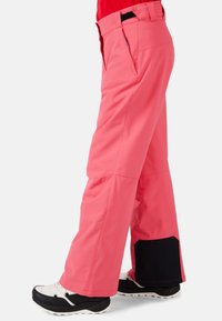 Růžové voděodolné lyžařské kalhoty s volným střihem, obsahující kapsy, zesílené lemy a kontrastní černé detaily na manžetách.