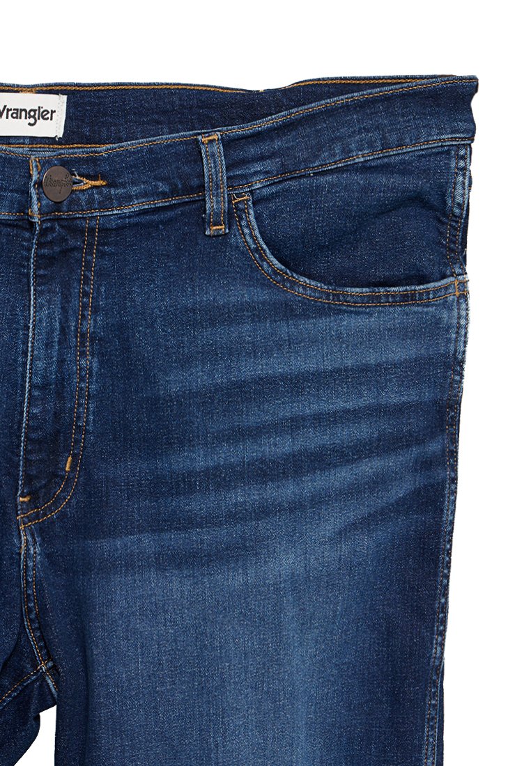 Ciemnoniebieskie dżinsy o prostym kroju, pięciokieszeniowe, z widocznymi szwami i metką z logo na pasku.