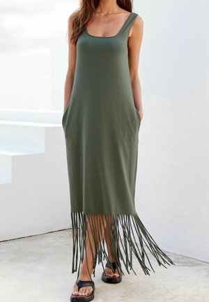 Robe maxi sans manches vert olive avec un col en U, deux poches latérales et des franges au bas. Tissu lisse et doux.