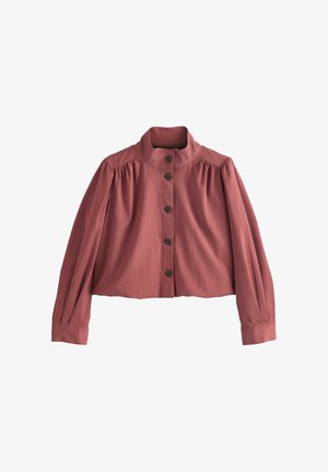 Langærmet bluse i støvet rosa med høj krave, fem sorte knapper ned foran og diskrete læg nær skuldre og manchetter.