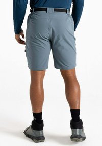 Graue Shorts für draußen mit einem seitlichen Reißverschlussfach und Gürtelschlaufen, kombiniert mit schwarzen Socken und grauen Wanderschuhen, von hinten betrachtet.