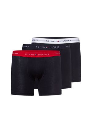 Tre paia di boxer neri da uomo con elastici in rosso, nero e bianco, ciascuno con il logo Tommy Hilfiger.