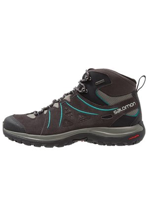 Dark gray mid-height hiking boot with teal accents, lace-up front, textured sole, and Salomon branding on the side and heel loop.