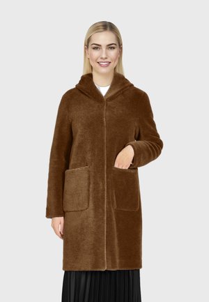 Robe en peluche marron avec capuche, deux poches avant, texture douce et coupe décontractée, présentée sur un fond neutre.