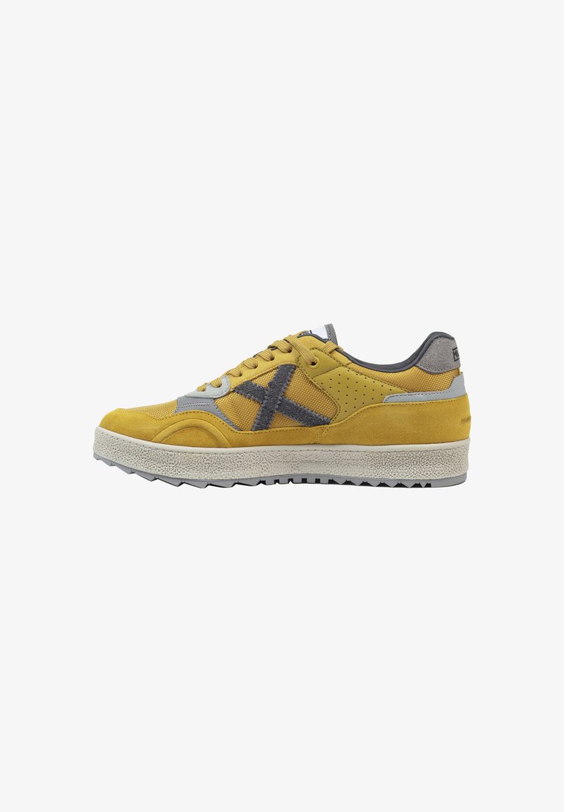 Sneakers in suede giallo con accenti grigi, suola piatta, suola in gomma texturizzata e dettagli perforati sui lati.