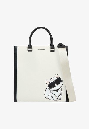 Fehér és fekete táska fekete fogantyúval és pánttal, amelyen egy rajzfilmszerű macska látható, amely túlságosan nagy fekete napszemüveget visel a jobb alsó oldalon.