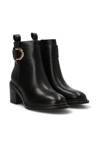 Botas negras hasta el tobillo hechas de cuero suave, con punta redondeada, tacón apilado y un detalle de hebilla en tono dorado en la correa del tobillo.
