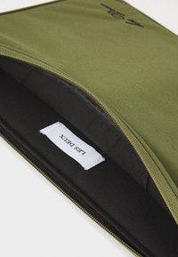 Olive green laptop sleeve with a smooth texture, zipper closure, and black interior. Includes a white label with "LETS DETUX" printed.