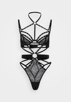 Zwart lingeriesetje met een gaasontwerp met zebrapatroon, versierd met zilveren studs en intrigerende banddetails overal.