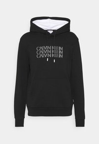 Felpa nera in misto cotone, con cappuccio regolabile, tasca frontale e scritta ripetuta "CALVIN KLEIN" in bianco sul petto.