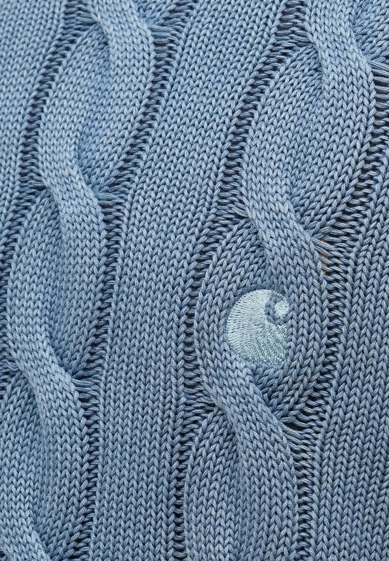 Lichtblauw gebreid textiel met een kabelbreipatroon met verhoogde twists en een glad rond gebreid detail binnen het ontwerp.