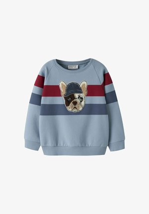 Sweat-shirt bleu clair à manches longues avec des rayures rouges et bleu marine et un écusson représentant un bouledogue français portant une casquette bleu marine au centre devant.