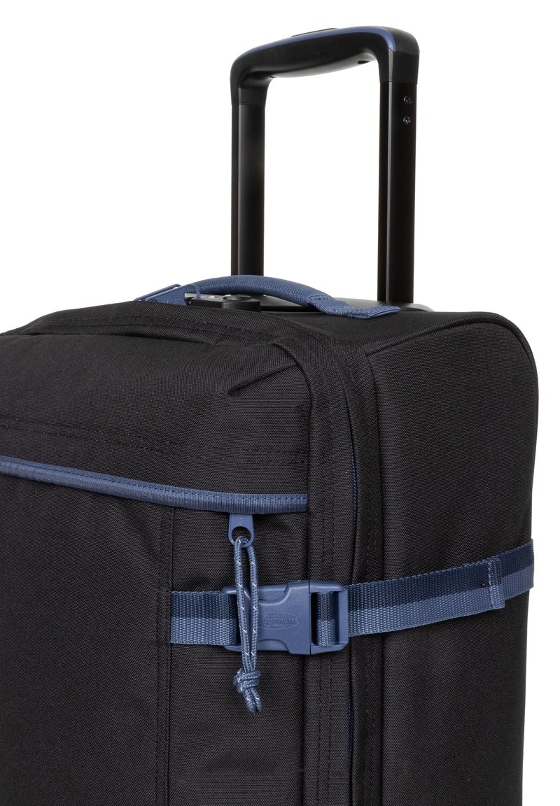 Valise en tissu noir avec une poignée rétractable, des accents bleus, une poche à fermeture éclair et une sangle avec une boucle pour sécuriser le contenu.