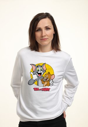 Weißer Pullover mit einem grafischen Druck von den Cartoonfiguren Tom und Jerry, mit einem gelben Kreis im Hintergrund und rotem Text darunter.