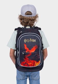 Batoh s motivem Harryho Pottera, černá látka, obsahuje design červeného fénixe s plameny, bílé akcenty, nastavitelné popruhy a zipy.