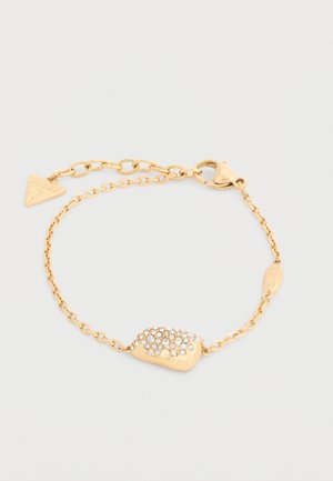 Gouden kettingarmband met een rechthoekige hanger versierd met kleine heldere kristallen en een driehoekige logohanger bij het slot.