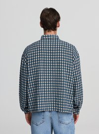 Camicia a maniche lunghe a quadri in blu, bianco e beige. Dotata di colletto alla francese e vestibilità comoda con orlo arrotondato. Tessuto dalla texture morbida.