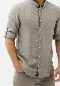 Camicia di lino grigia chiara con colletto button-down, bottoni frontali a tutta lunghezza e maniche rolled-up. Dettaglio a righe visibile notable sul colletto.