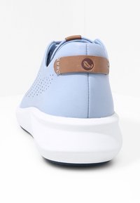 Ljusblå sneaker med en slät yta, perforerad sidodetalj och vit sula. Brunt läderaccent på hälen med logotyp.