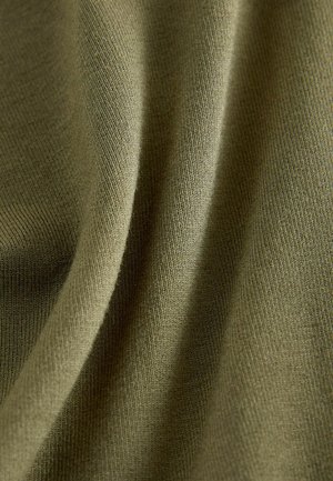 Khaki kangas ribaga tekstuuriga, näidates sujuvaid, voolavaid voldikesi ja peent värvivarjundit, mis viitab kergele ja venivale materjalile.