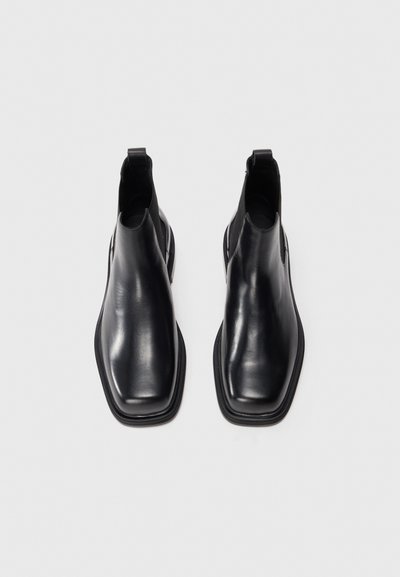 Pair of sleek black leather Chelsea boots with square toes and pull tabs, shown side by side on a white background.