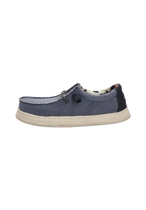 Zapato azul de tela tipo slip-on con superficie texturizada, plantilla de yute trenzado y forro interior con diseño. Cuenta con un lazo para facilitar el uso.