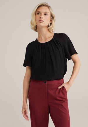 Zwarte, kortdoorhalige blouse met een geplooide design en ronde halslijn, gecombineerd met aansluitende bordeauxrode broek. Glad textuur, casual stijl.