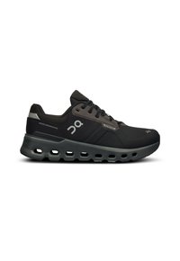 Scarpe sportive nere con una tomaia texturizzata, dotate di una suola curva con fori vuoti e accenti grigi. Presentano il logo del marchio sul lato.