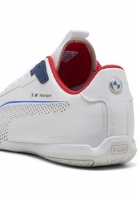 Hvide sneakers med blå og røde detaljer, med perforerede elementer, logo og struktureret sål. Materialet ser glat ud med et strømlinet design.