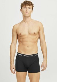 Boxers noirs en tissu lisse avec une coupe ajustée, dotés d'une ceinture blanche contrastante avec le logo "JACK & JONES".