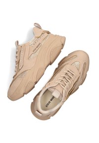 Beige sportieve sneakers van mesh en nep-suède materiaal, met zilveren studs, metalen accenten en gestructureerde zolen. Gehaakt met een gevoerde kraag.