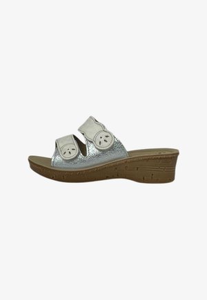 Sandalo slip-on argento con due cinturini bianchi regolabili e tacco a zeppa marrone con dettagli strutturati.