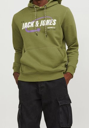 Sudadera verde oliva con cordones, bolsillo frontal y gráfico en blanco y púrpura de "JACK & JONES". Combinada con pantalones cargo negros.