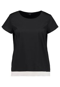 Blusa nera a maniche corte con scollo rotondo e orlo bianco a contrasto. Tessuto morbido con vestibilità ampia. Nessun motivo o accentuazione aggiuntiva.