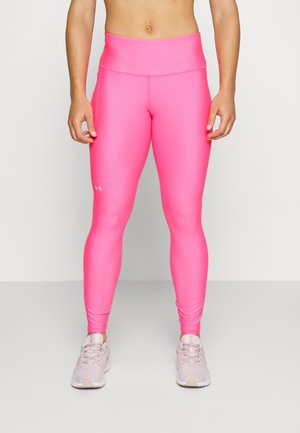 Leggings taille haute roses en matière extensible, présentant une texture lisse et une coupe ajustée. Logo affiché sur la jambe inférieure.