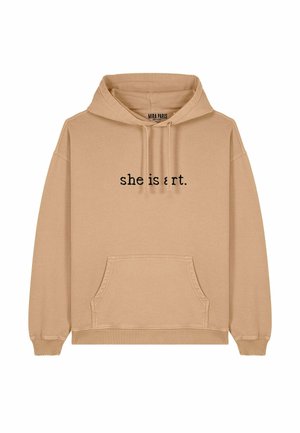 Beige hooded sweatshirt met een kangoeroezak. Zwarte tekst met de woorden "she is art." op de voorkant. Zachte textuur, ontspannen pasvorm en ribgebreide manchetten.