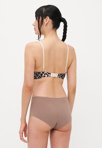 Soutien-gorge en imprimé léopard avec bretelles ajustables et fermeture à crochet ; associé à un slip taille haute uni marron. Texture de tissu lisse.