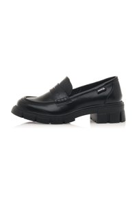 Scarpa in pelle nera stile mocassino con punta arrotondata, suola spessa e rigida, e cuciture decorative sul pannello frontale. Presenta un'etichetta con il logo sul lato.