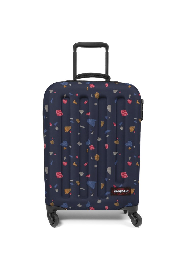 Valigia rigida di colore blu navy con superficie texturizzata, caratterizzata da un motivo geometrico colorato di varie forme. Include una maniglia estraibile e ruote.