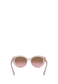 Lunettes de soleil en forme d'œil de chat avec une monture transparente rose clair et des verres dégradés bruns. Accents en matériel doré sur les branches.