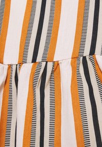 Tejido a rayas con líneas verticales en naranja, beige y negro, con detalles fruncidos en la costura y un acabado texturizado.