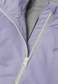 Šviesiai purpurinė striukė su lygia daina, su balta užtrauktuku ir pilku audinio pamušalu. Siuvinėtas logotipas šalia užtrauktuko.